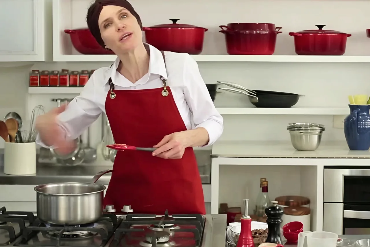A chef explica o passo com a espátula na mão